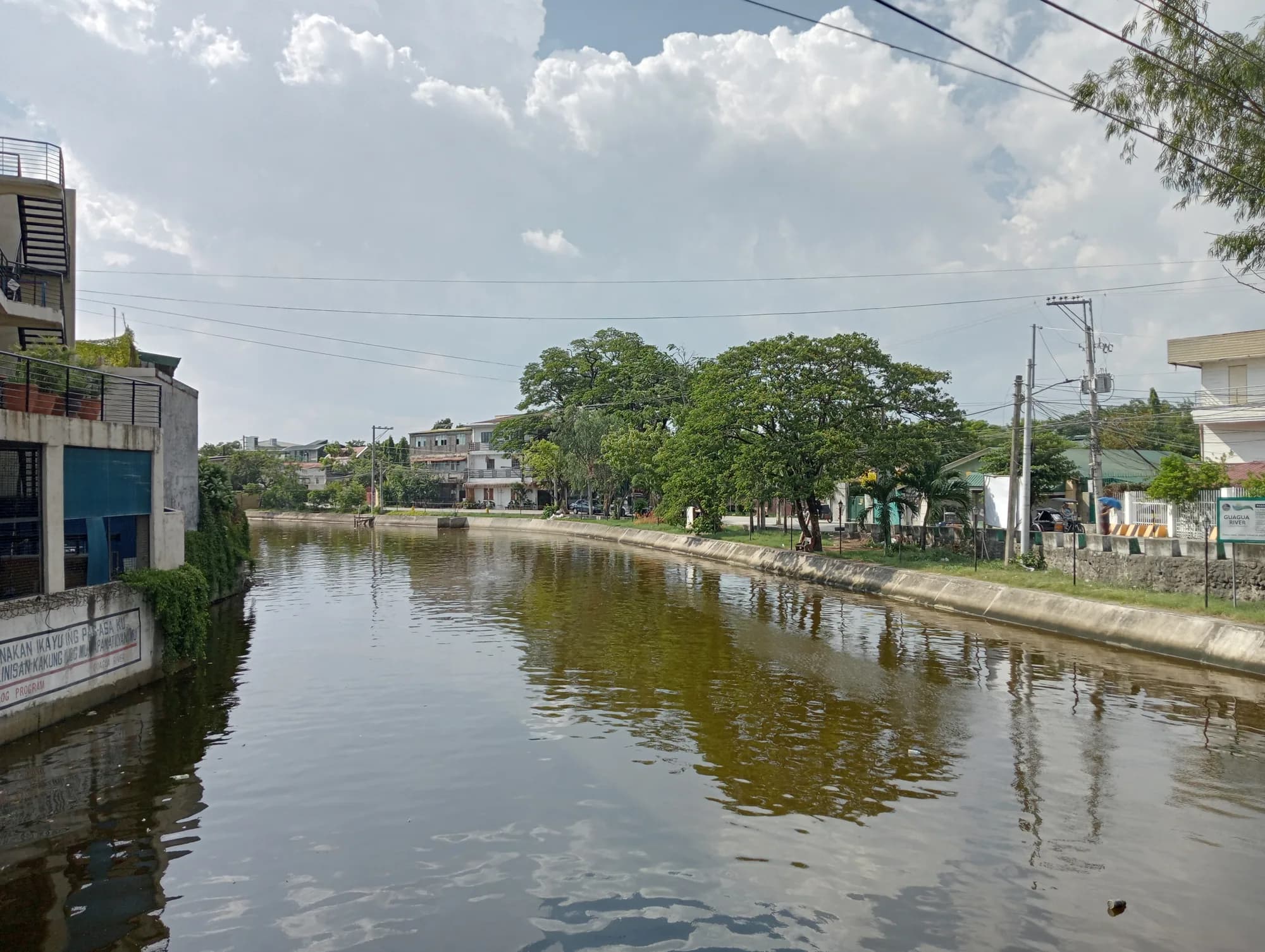 The Guagua River lined with trees and houses