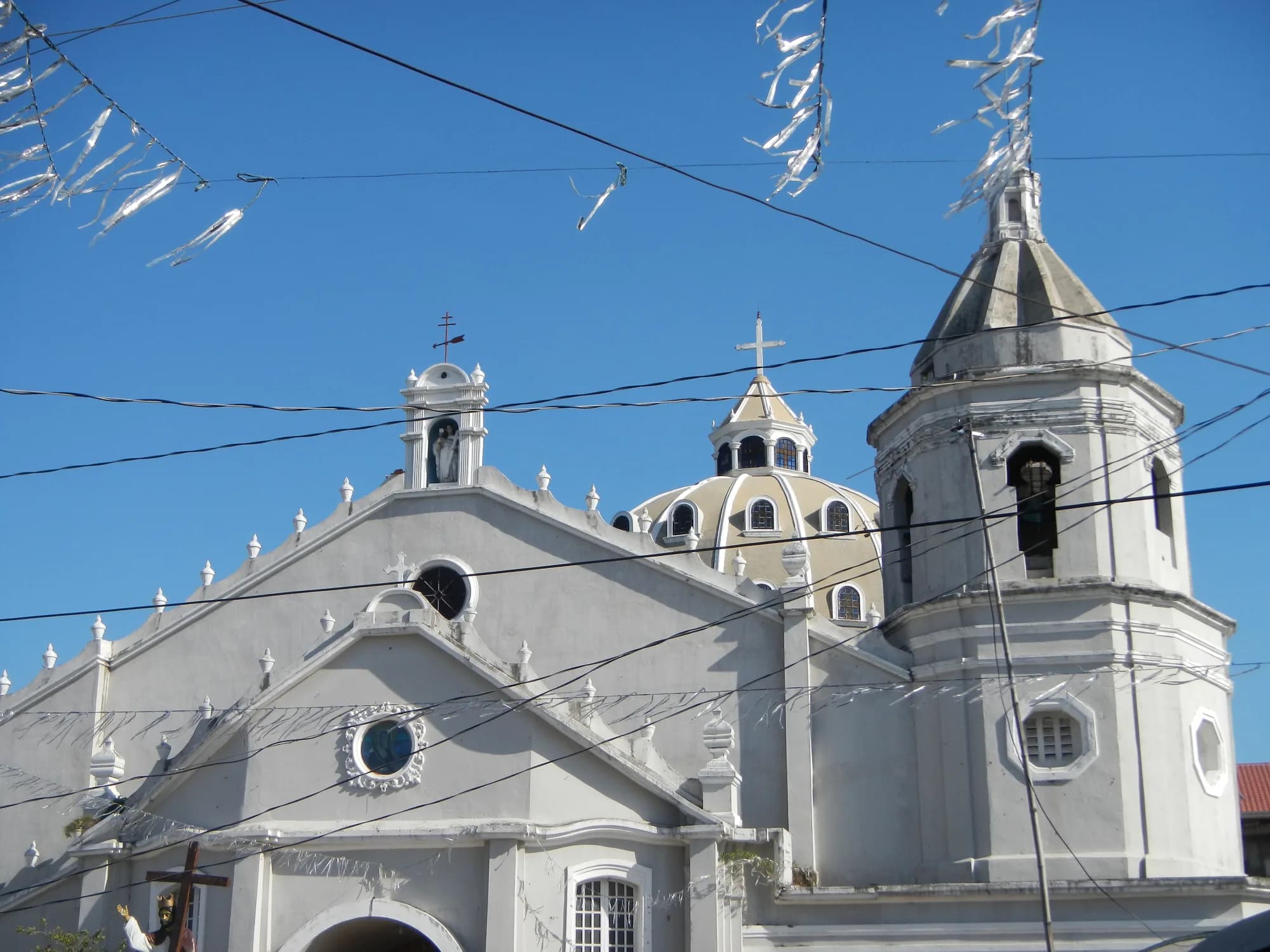 The white facade and dome of Saint Lucy Church in Sasmuan